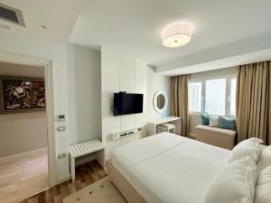 a hotel room with a bed and a television at Limani Deluxe Apartments in Sarandë