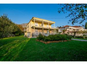 a large house with a lawn in front of it at Apartments Nada in Starigrad-Paklenica