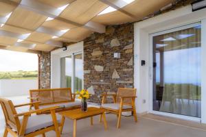 a porch with two chairs and a table and a window at Rena Majore Country Resort in Lampianu