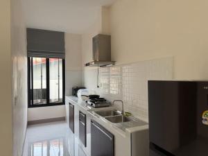 a white kitchen with a sink and a stove at Baan Santi in Koh Phangan in Thongsala