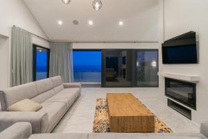 a living room with a couch and a tv and a table at Miles End Pezula in Knysna
