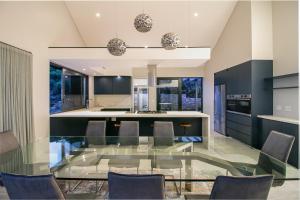 a dining room with a glass table and chairs at Miles End Pezula in Knysna