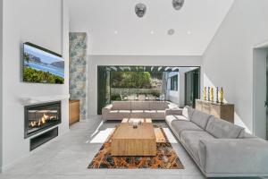 a living room with a couch and a fireplace at Miles End Pezula in Knysna +45 photos