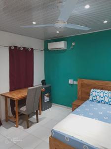 a bedroom with a bed and a desk and a table at La Résidence in Lomé