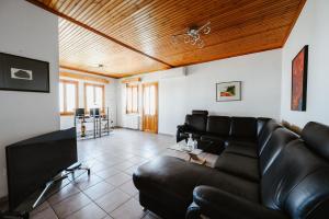 un soggiorno con divano in pelle nera di Panoramic View Villa a Stagiates