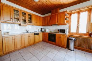 una cucina con mobili in legno e un forno a piano cottura di Panoramic View Villa a Stagiates Altre 36 foto
