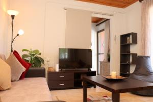 a living room with a couch and a flat screen tv at Charming Villa by the Sea in Nea Kalikratia