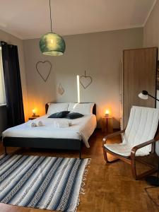 une chambre avec un lit blanc, une chaise et une suspension dans l'établissement Il Nido, à Turin