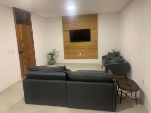 a living room with a couch and a flat screen tv at Sunset Patacho in Pôrto de Pedras