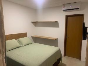 a small bedroom with a bed and a door at Sunset Patacho in Pôrto de Pedras +33 photos