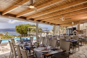 a restaurant with tables and chairs and a pool at Panorama Fanari studios and apartments in Argostoli