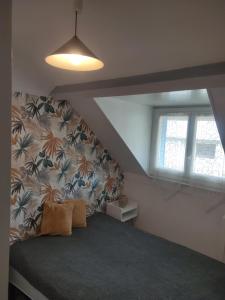 a room with a bed in a attic with a window at Villa Lumière in La Bourboule