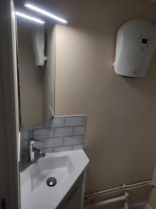 a bathroom with a sink and a large mirror at Villa Lumière in La Bourboule