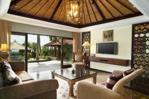 a living room with a tv and a couch and a table at Sheraton Senggigi Beach Resort in Senggigi