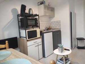 a small kitchen with a microwave and a counter top at Villa Lumière in La Bourboule