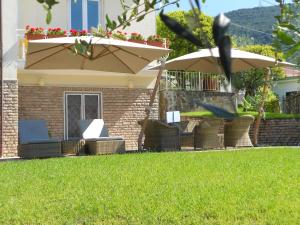 a group of chairs and umbrellas in a yard at Albergo Blueline in Tellaro