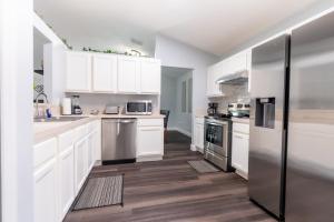 a kitchen with white cabinets and stainless steel appliances at Family Retreat Near NAS JAX and Orang Park Mall with Gameroom in Jacksonville