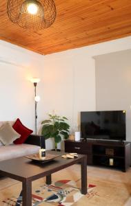 a living room with a couch and a flat screen tv at Charming Villa by the Sea in Nea Kalikratia