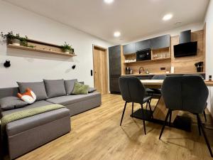 a living room with a couch and a table with chairs at Apartmány nora - Příchovice in Kořenov