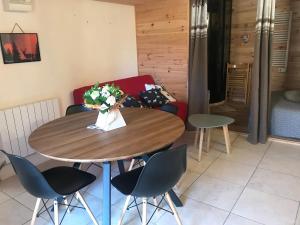 a table and chairs in a room with a couch at Les chardons bleus in Formiguères