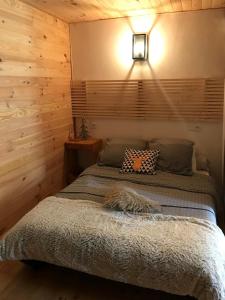 a bedroom with a bed with a wooden wall at Les chardons bleus in Formiguères