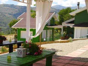 uma casa verde com uma mesa com flores em Ktima Noosfera Wellness & Retreat Center em Kariá