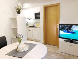 a living room with a table and a television at Auszeit am Petersdorfer See in Funfseen