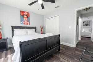 a bedroom with a black bed and a ceiling fan at Family Retreat Near NAS JAX and Orang Park Mall with Gameroom in Jacksonville
