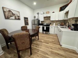 ネダーランドにあるTexas Ranch 2BR 1BAの白いキャビネットとテーブルと椅子のあるキッチン