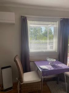 a table and a chair in a room with a window at Flott sted med utsikt over hele byen in Stavanger