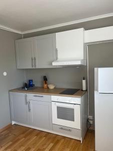 a kitchen with white cabinets and a white refrigerator at Flott sted med utsikt over hele byen in Stavanger