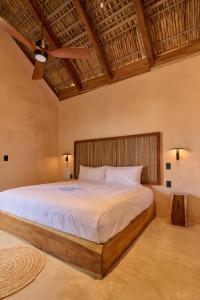 a bedroom with a large bed with a ceiling fan at Pan Beach in Brisas de Zicatela +93 photos