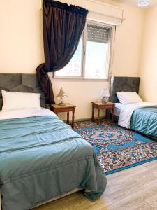 a bedroom with two beds and a window at Appartement charmant à deux pas de Rabat Tram et Gare à pied in Sale