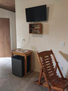 a room with a desk and a chair and a tv at Chalé com Lareira in Cunha