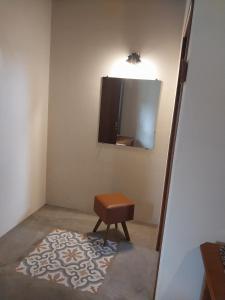 a room with a stool and a mirror and a rug at Chalé com Lareira in Cunha