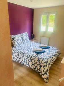 a bedroom with a bed with a blue and white comforter at Maison familiale - Jardin - Parking - Wifi in Pithiviers