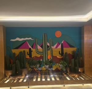 a mural of a desert with cacti on a wall at Hotel y Villas Gran Vía, Tultitlán in Mexico City