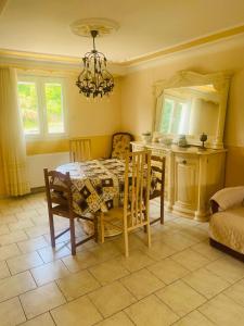 a dining room with a table and chairs and a kitchen at Maison familiale - Jardin - Parking - Wifi in Pithiviers