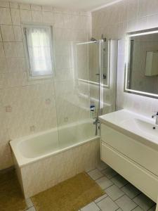 a white bathroom with a tub and a sink at Maison familiale - Jardin - Parking - Wifi in Pithiviers