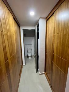 a bathroom with a toilet and a corridor with wooden doors at Fantástico Depa en BLUU con PLAYA ARTIFICIAL - Turquesa 208 - in Mazatlán