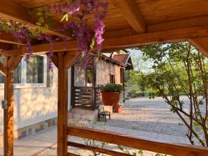 a wooden pergola with purple flowers hanging from it at Apartment Liso in Seliste Dreznicko