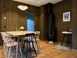 a dining room with a table and chairs and a fireplace at Lindvallen Ski Resort Pool and Padel - Sauna - 4 Guests in Sälen