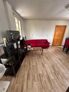 a room with a red couch and a wooden floor at Country House in Los Planes VACATION RENTAL in Panchimalco +21 photos