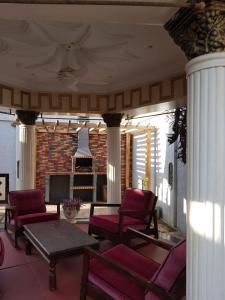 a porch with chairs and a table and a fireplace at The Manor in Lomé