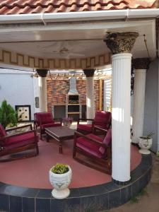 a covered patio with chairs and a table at The Manor in Lomé