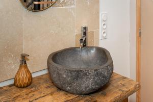 a bathroom with a stone sink on a wooden table at Le loft de la Casa Cota-Balnéo XXL in Rivesaltes +15 photos