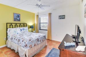 a bedroom with a bed and a desk with a television at Walk to Ocean Daytona Beach Shores Condo with Pool! in Daytona Beach Shores +22 photos