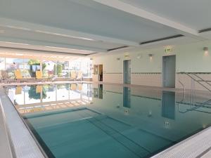 a swimming pool with a view of the water at 2-Raum FeWo Alpenveilchen - Hallenbad & Sauna in Fischen