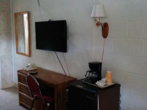 a room with a television and a desk with a chair at Starlight Motel in Big Pine