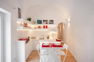 - une petite cuisine blanche avec une petite table et des chaises dans l'établissement Casina Caprese, à Capri